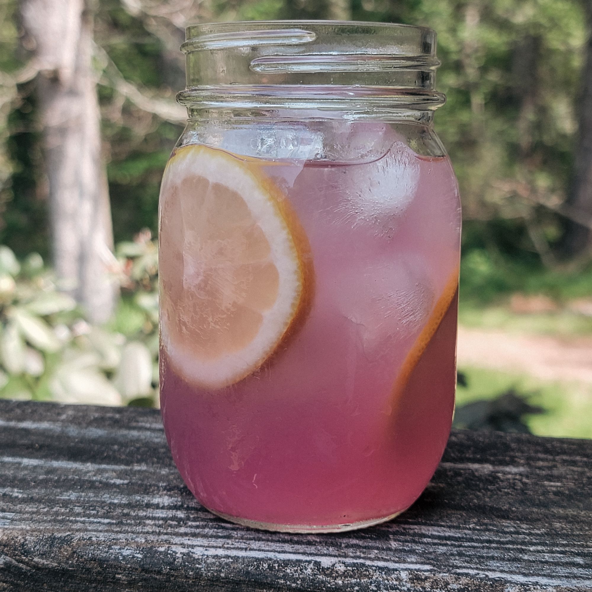 glass filled magic pink lemonade decorated with lemon slices